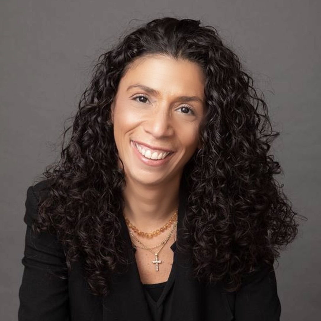 Tiz Simpson Head Shot Woman with curly hair smiling at camera