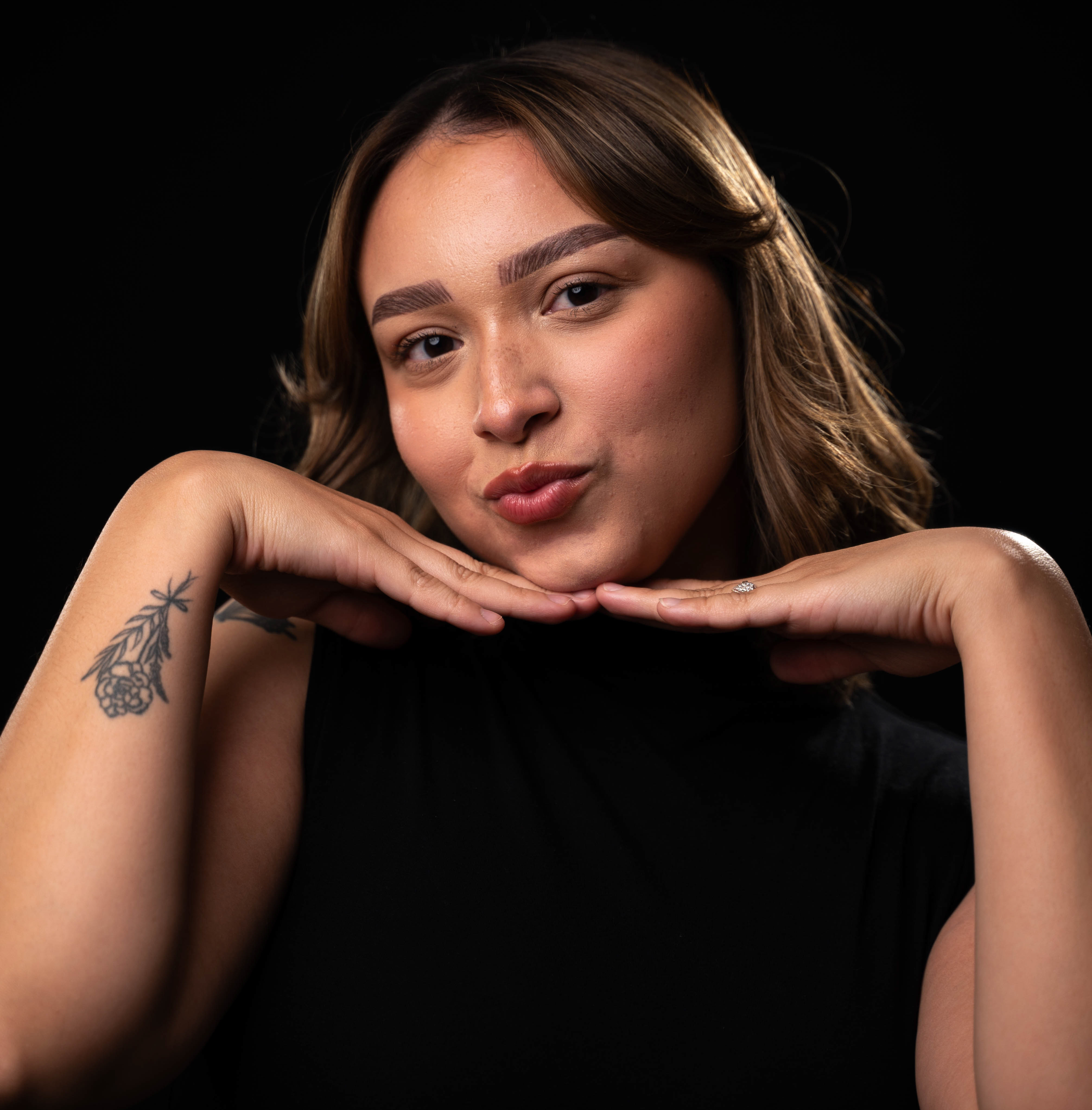 JADA-HEADSHOT girl with her two hands under her chin making a kissy face to camera